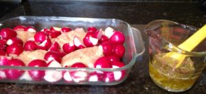 chicken and radishes in baking dish and marinade in measuring cup